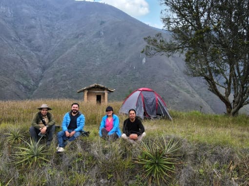 Camping in Gera Four happy campers pose for a photo in front of their tent with a spectacular view of the surrounding Andean landscape.