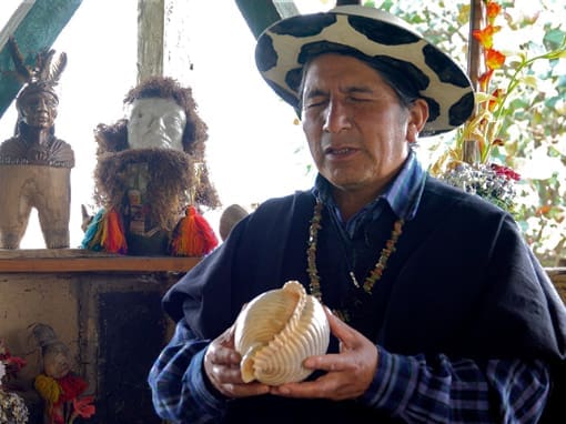 Taita Luis Taita Luis with closed eyes holds a conch shell while guiding a sacred ritual.